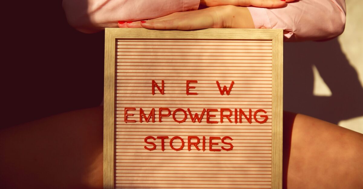 a person holding a sign that says new empowering stories