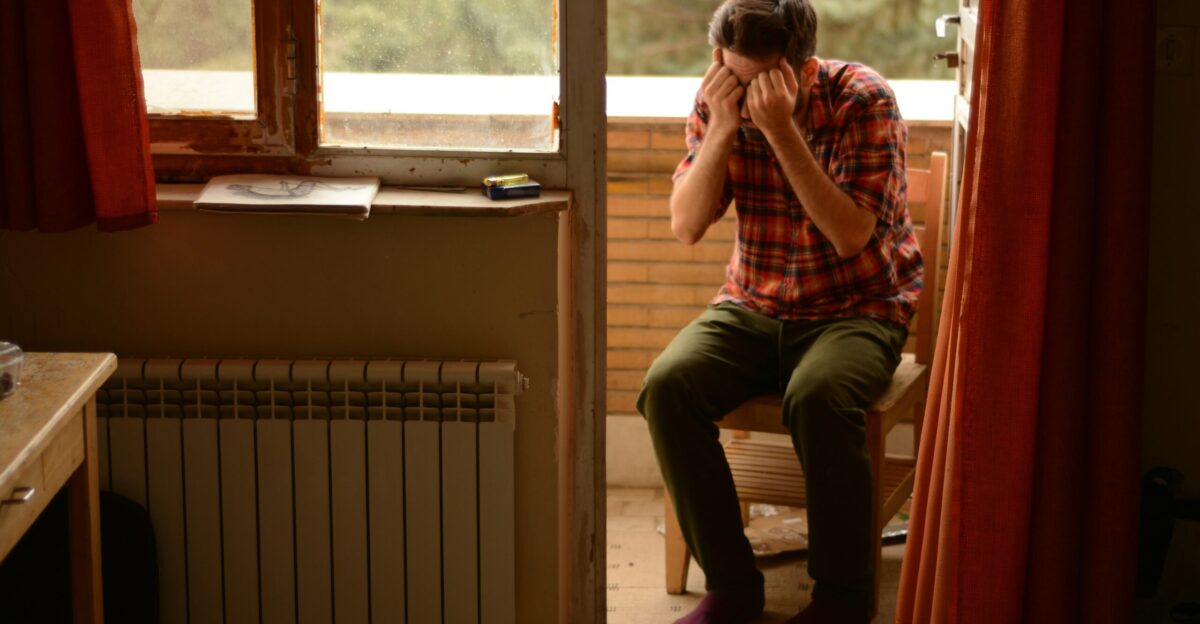 a person sitting on a chair looking out a window