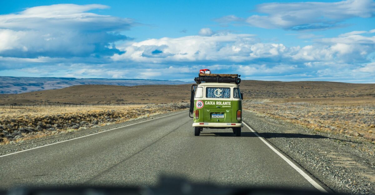 a green and white bus driving down a road