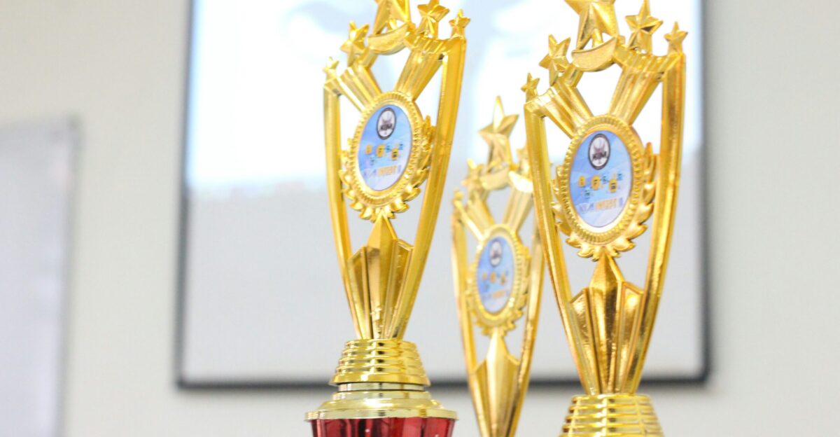 two red and gold trophies sitting on top of a table