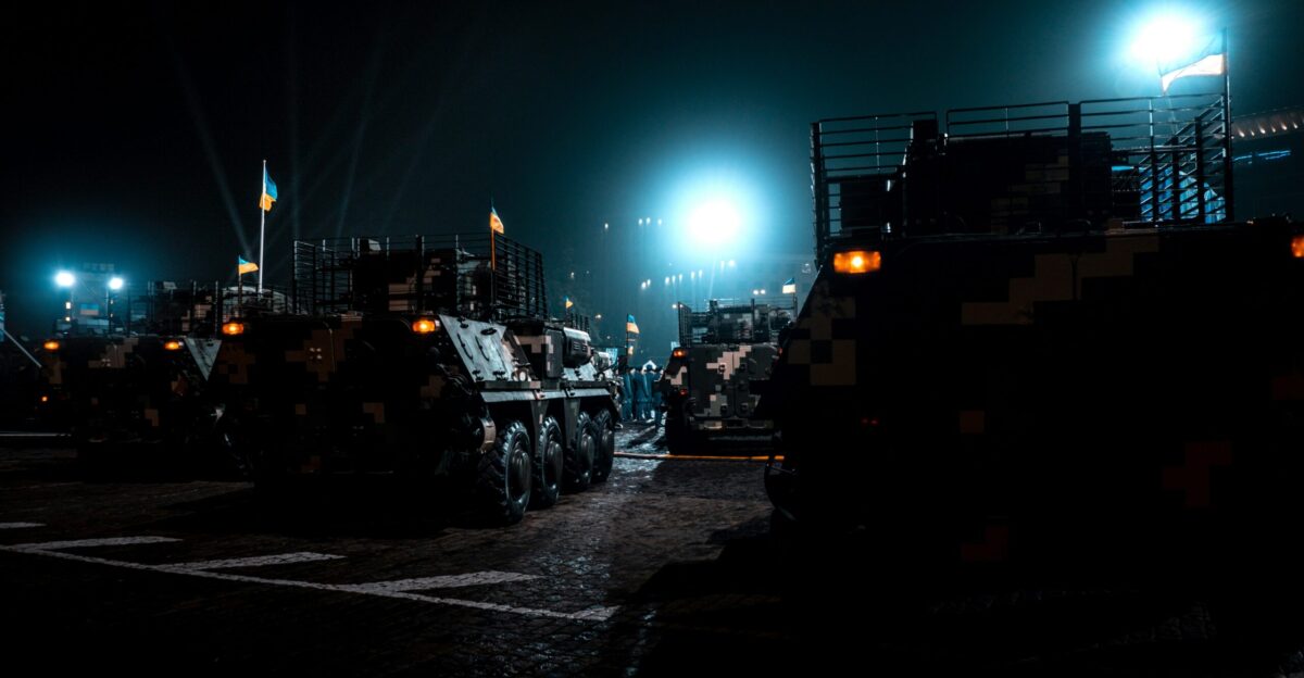military vehicles parked in a parking lot at night