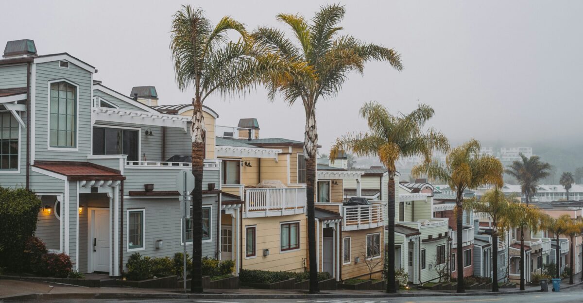 a row of houses on a street with palm trees