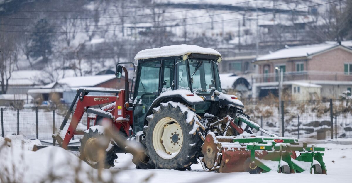 a tractor with a plow in the snow