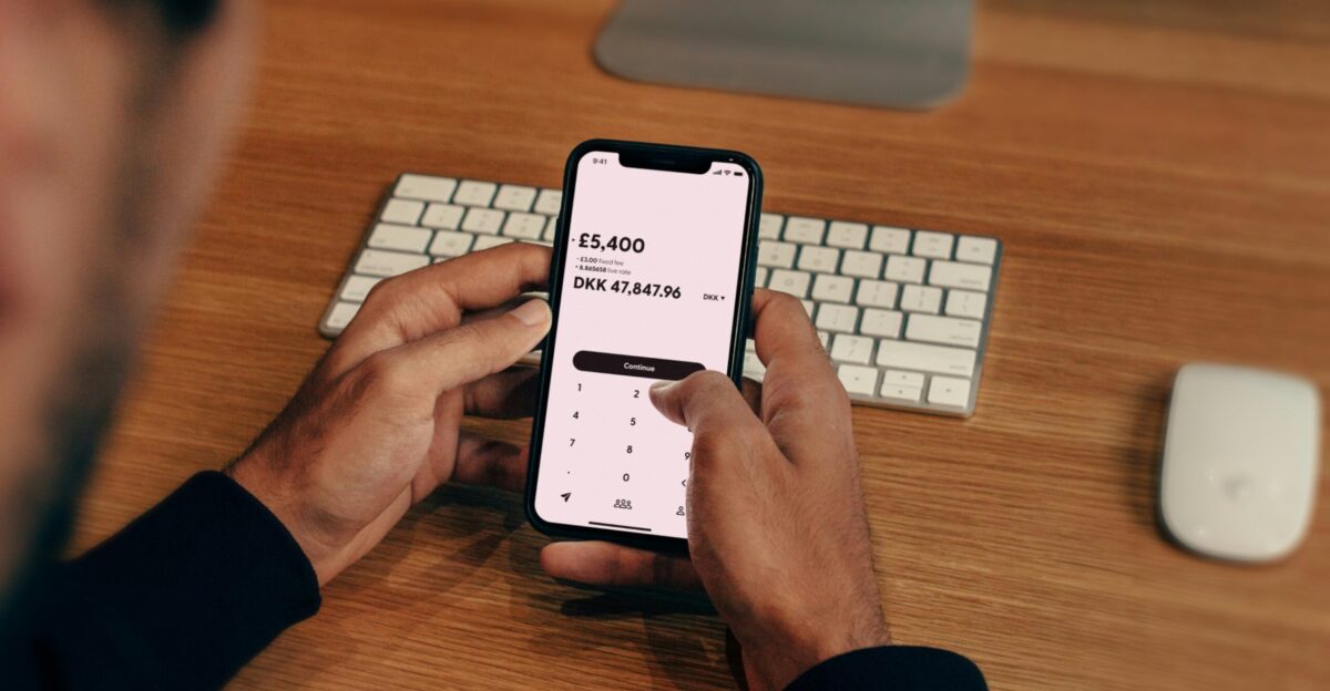 a man holding a cell phone in front of a keyboard