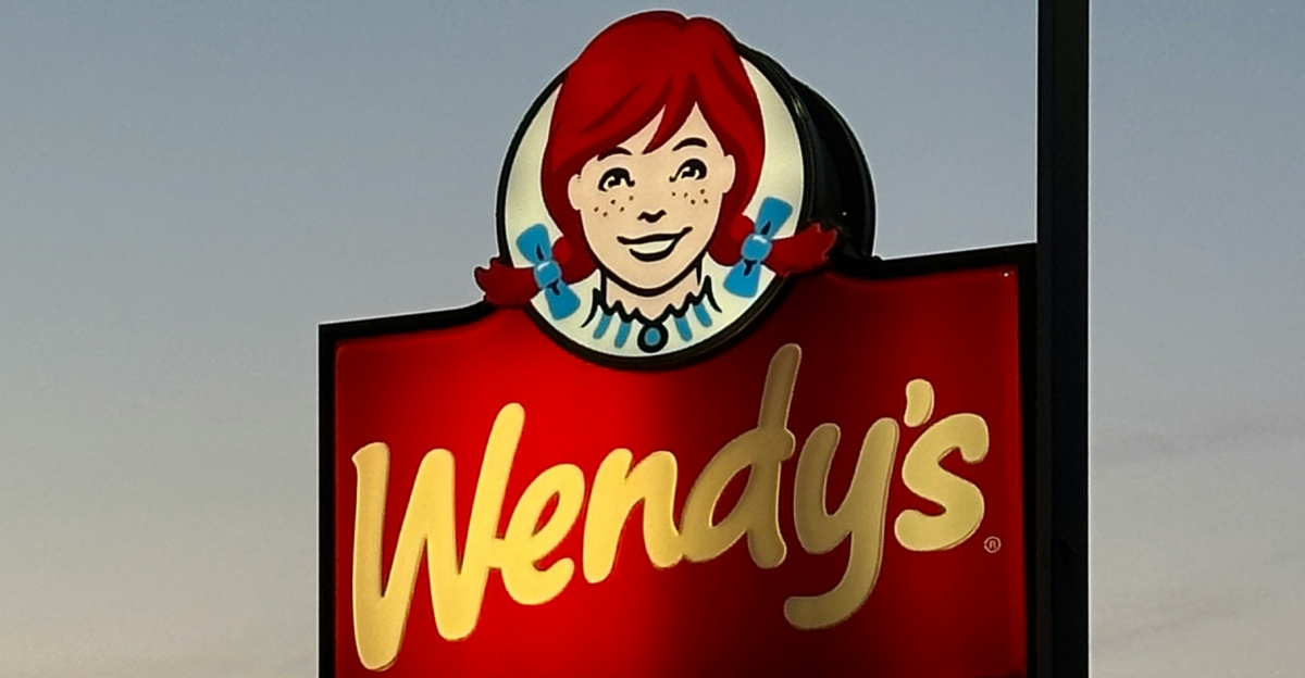 a sign for wendy's restaurant in a parking lot