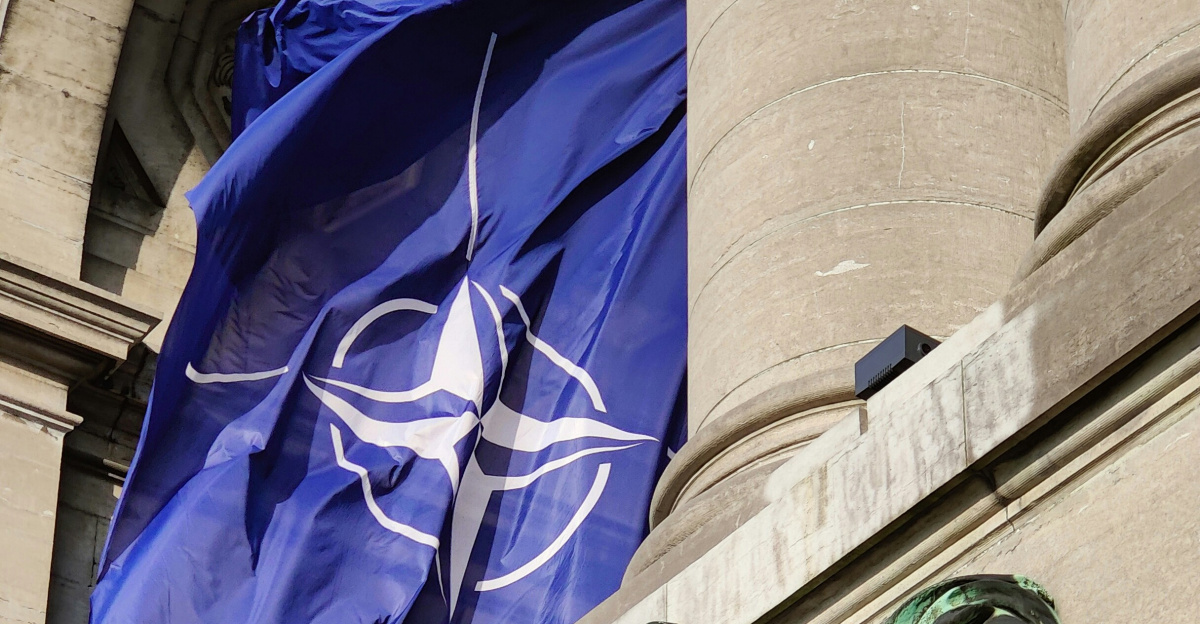 a statue of a man holding a flag in front of a building