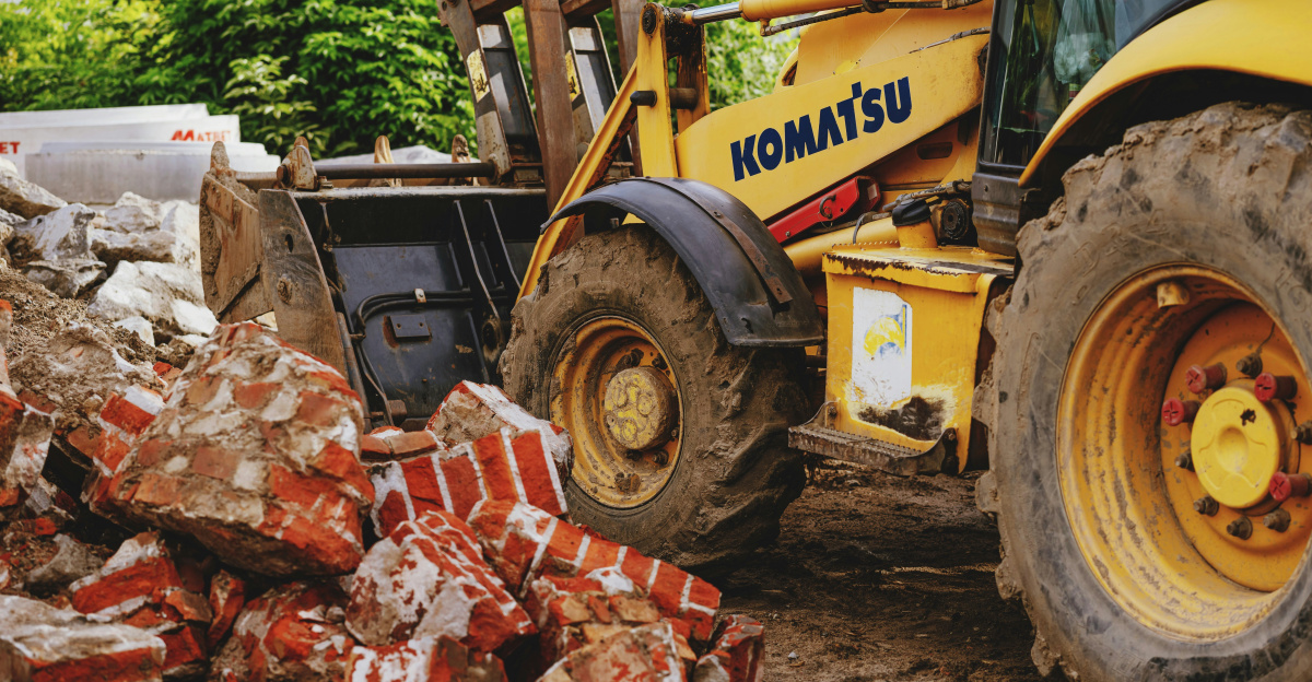 a tractor is parked next to a pile of bricks