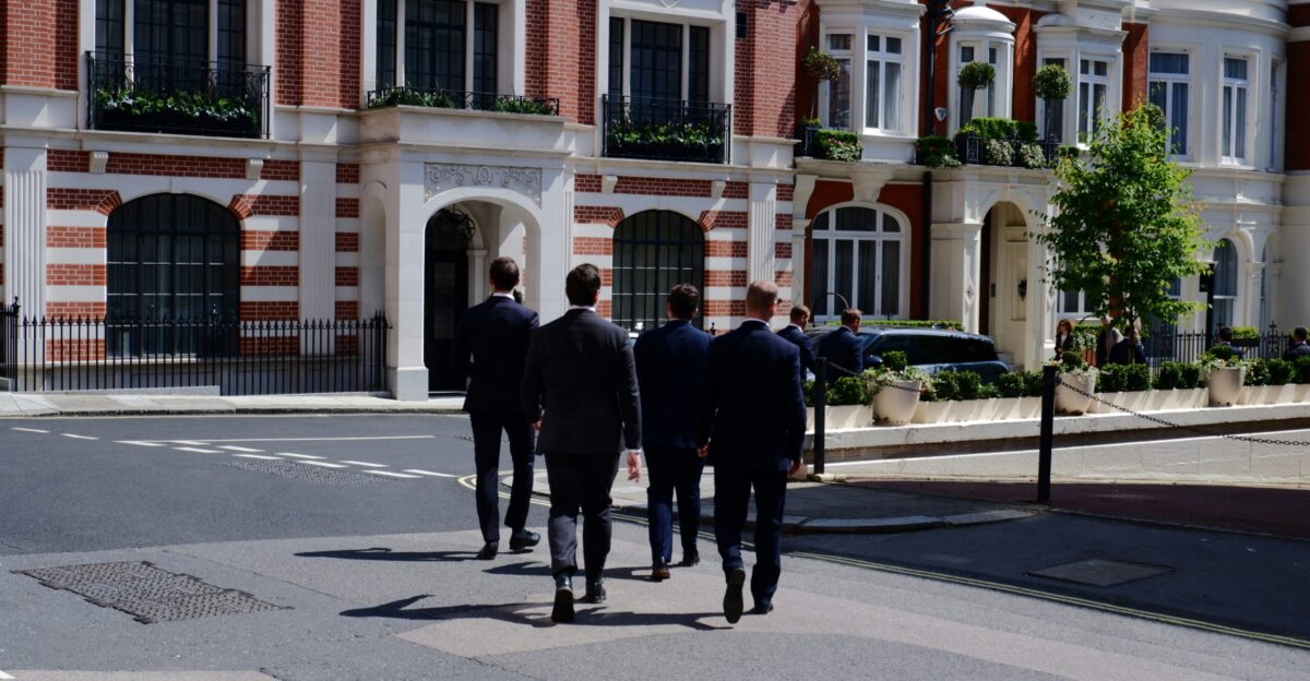 a group of men in suits walking down a street