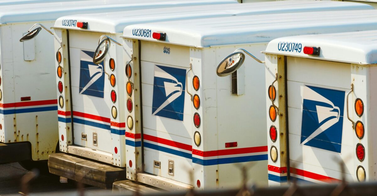a row of mail boxes behind a chain link fence