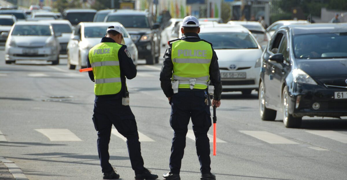 two police officers standing on the side of a road