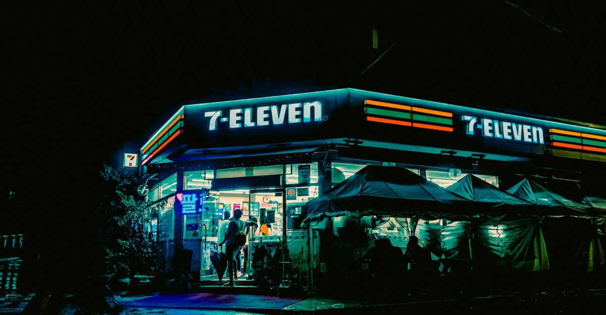 a street corner with a store lit up at night