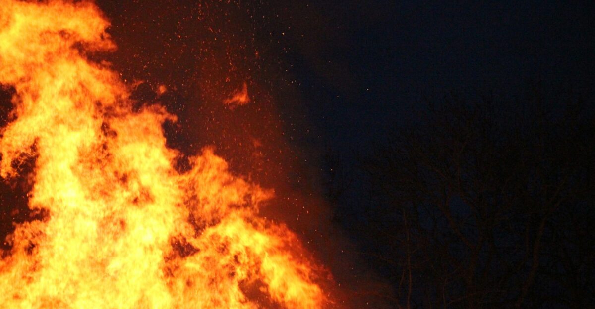 a fire hydrant spewing out flames at night