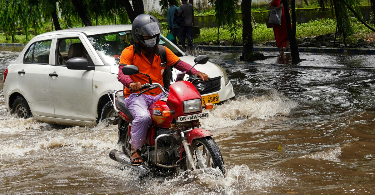a man riding a motorcycle through a flooded street