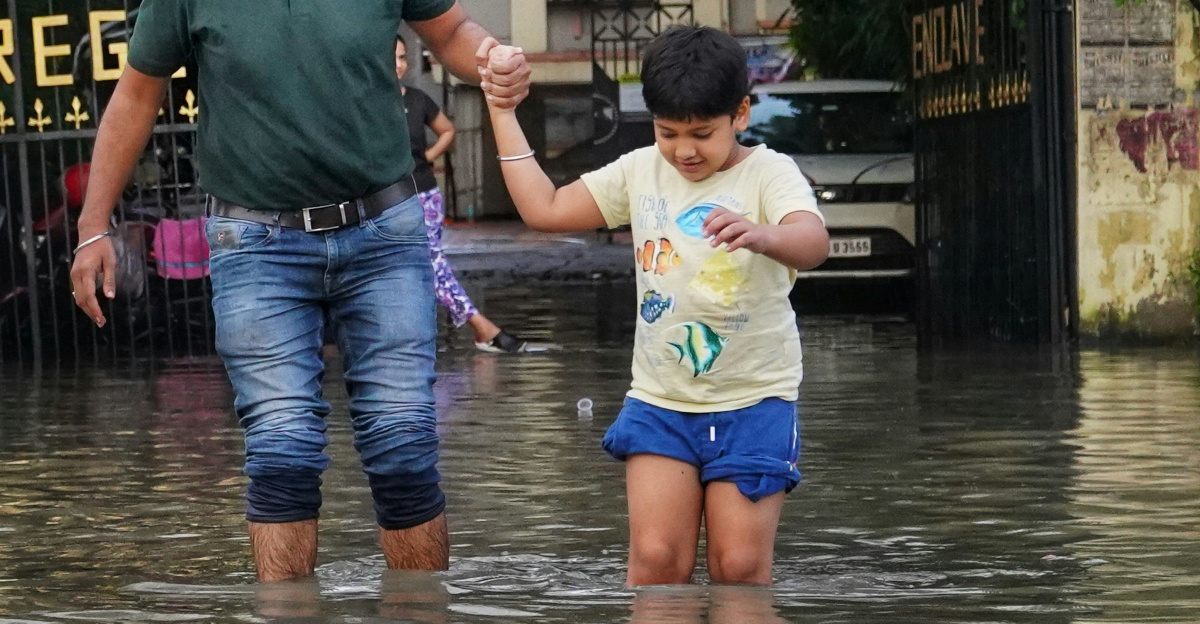 a man and a little girl walking through a flooded street