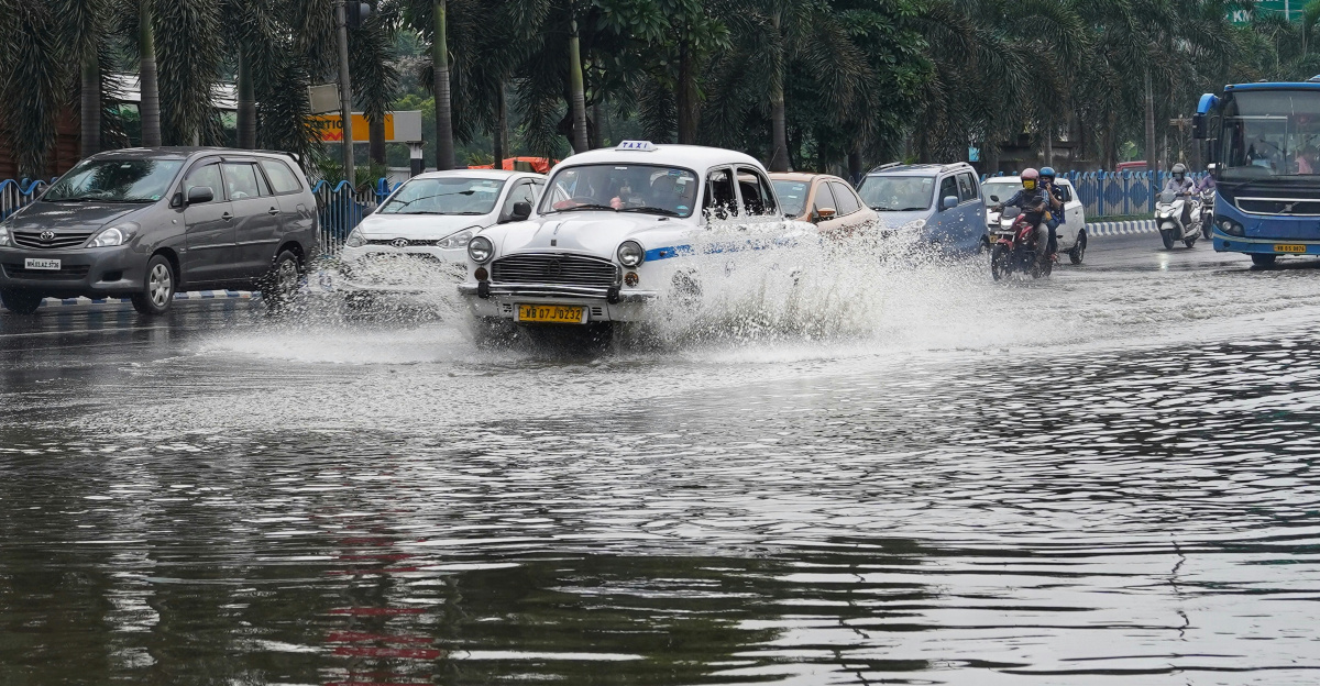 a group of cars driving down a flooded street