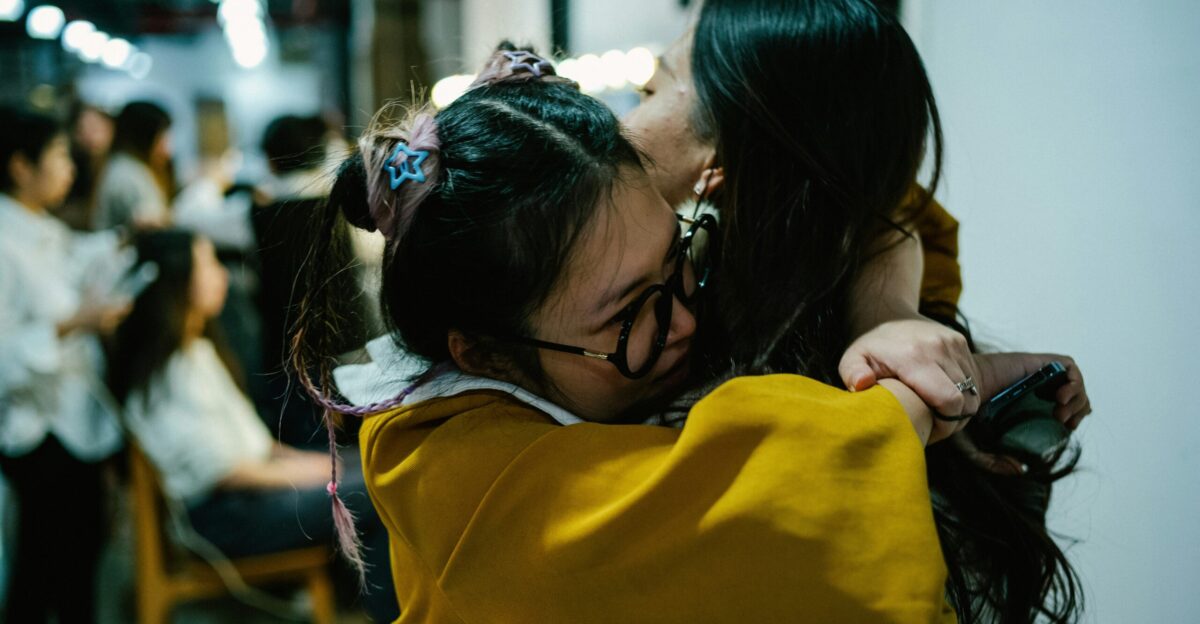 a couple of women hugging each other in a room