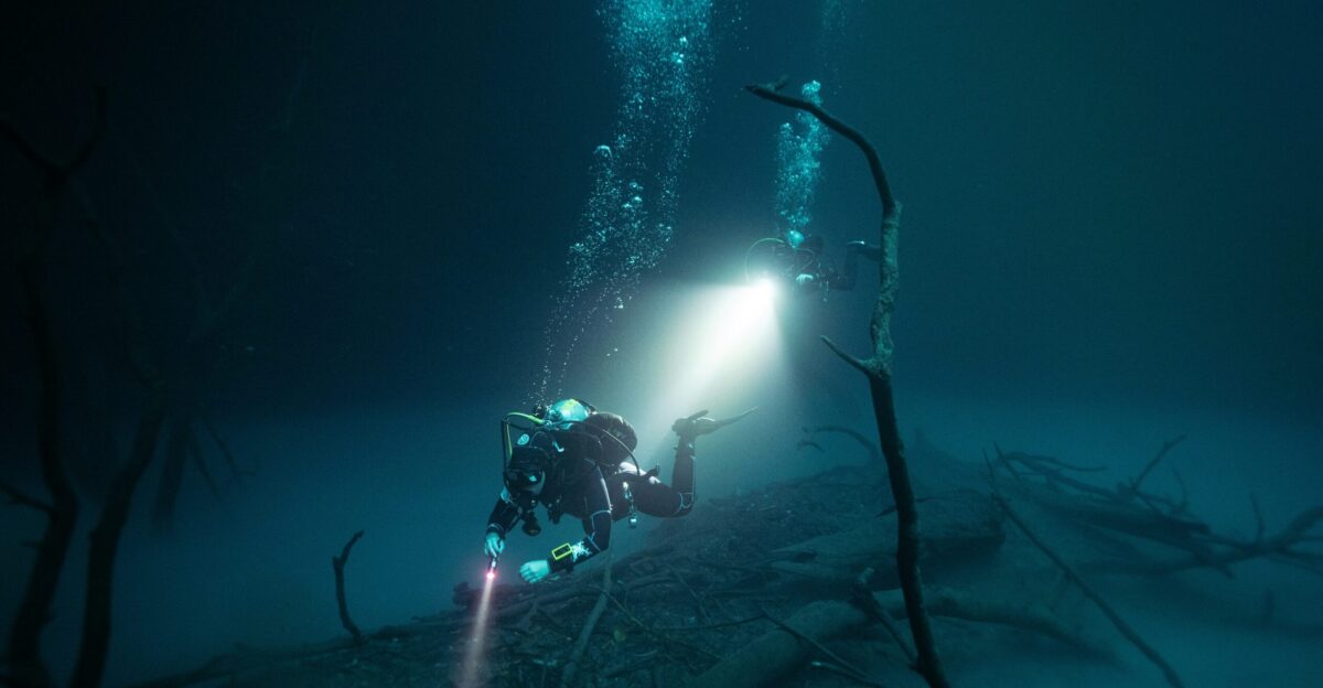 a scuba in the water with a flashlight