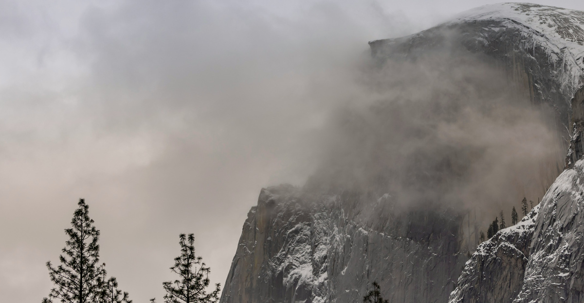 a mountain covered in snow surrounded by trees