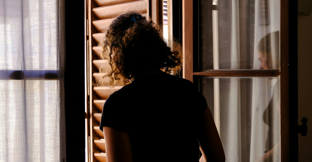 a woman is looking out of a window
