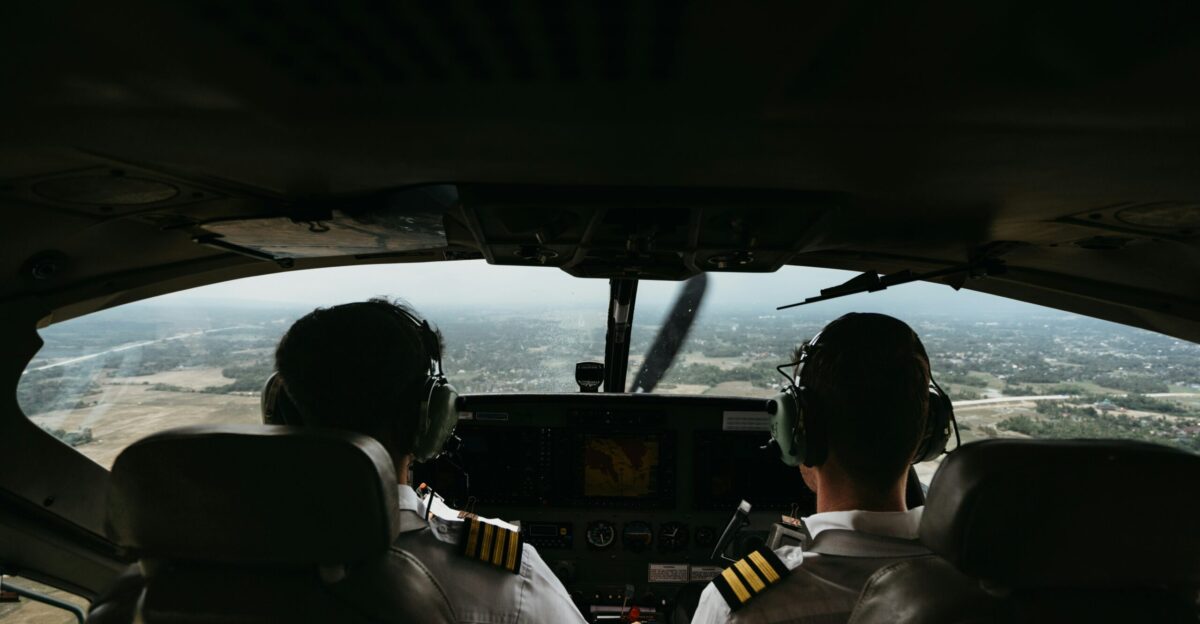 a couple of pilots sitting in the cockpit of a plane