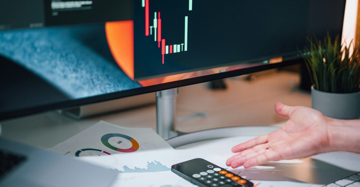 a person pointing at a calculator on a desk