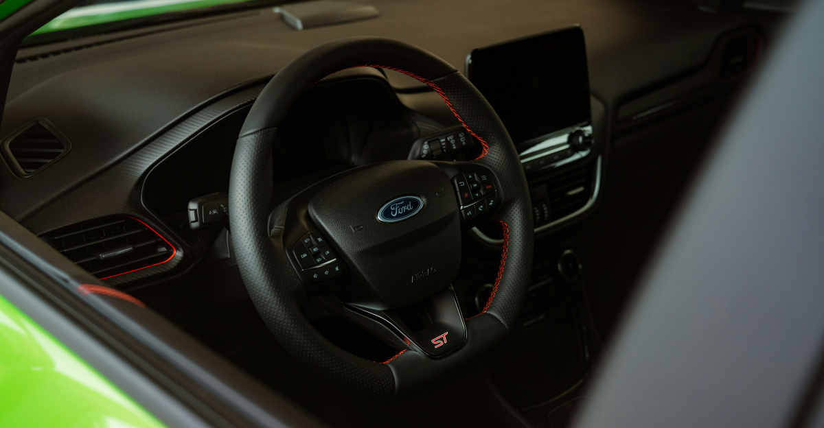 the interior of a green car with a steering wheel