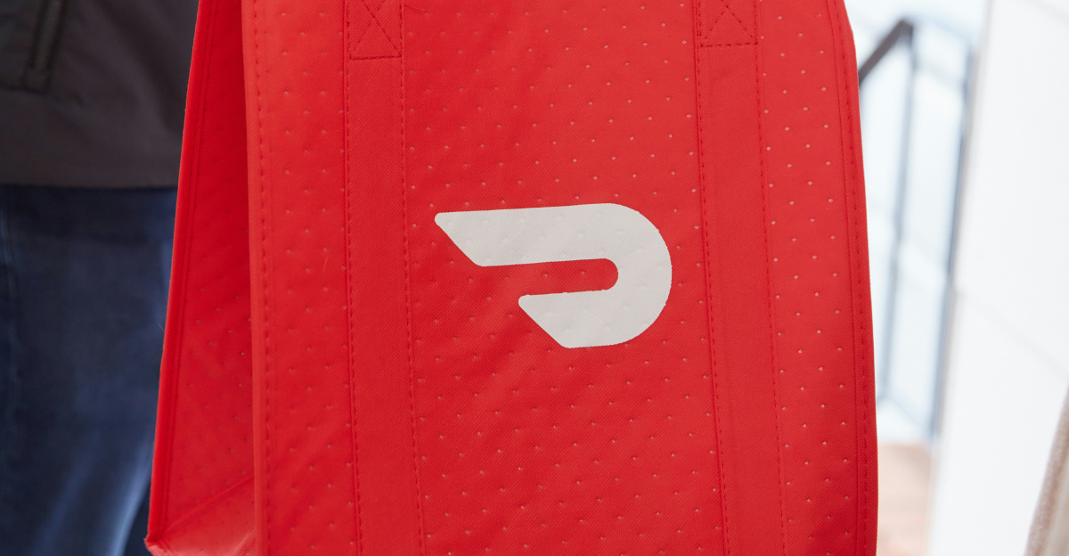 a person holding a red bag with the letter D on it
