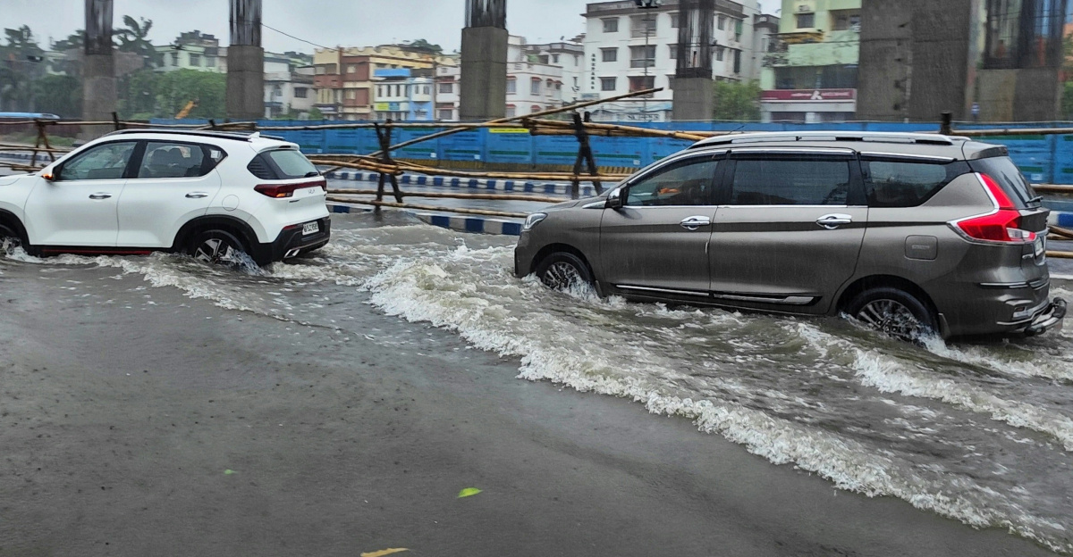 a couple of cars driving through a flooded street