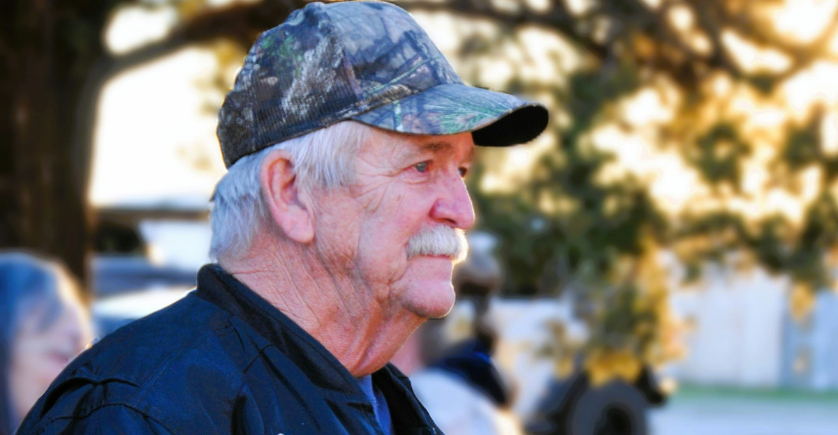 A man in a black jacket holding an american flag
