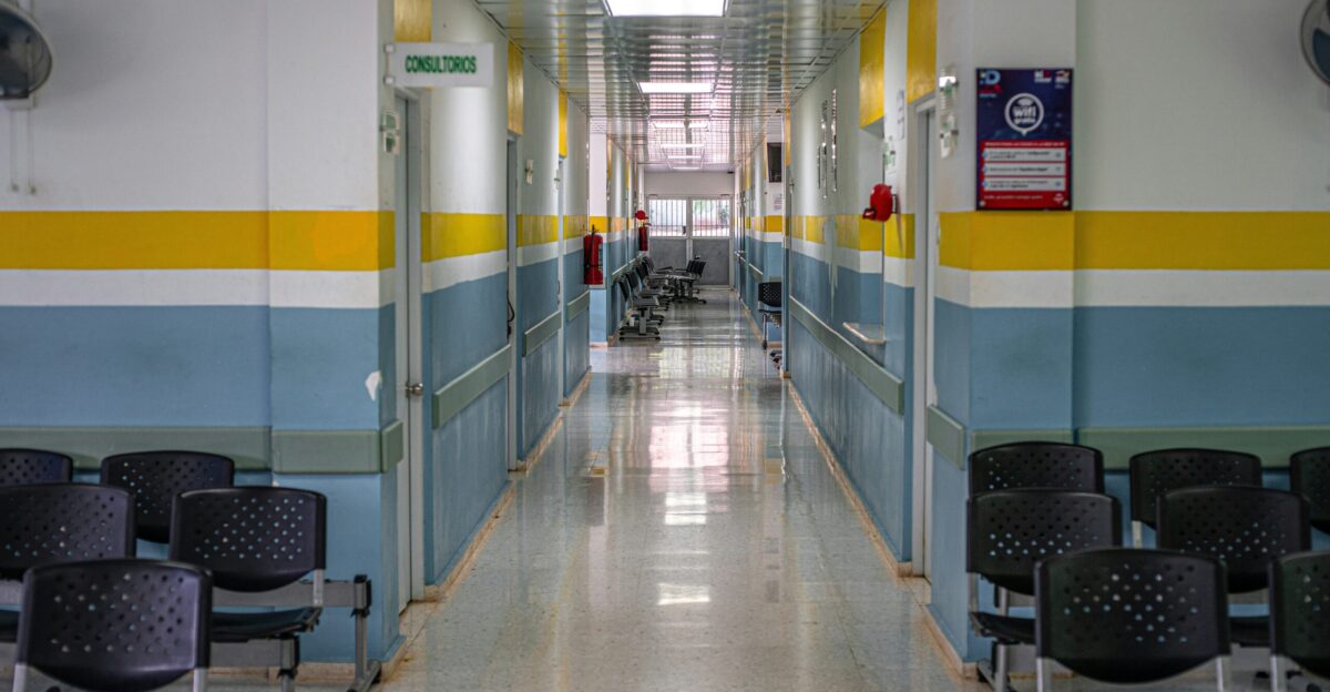 A long hallway with chairs and a clock on the wall