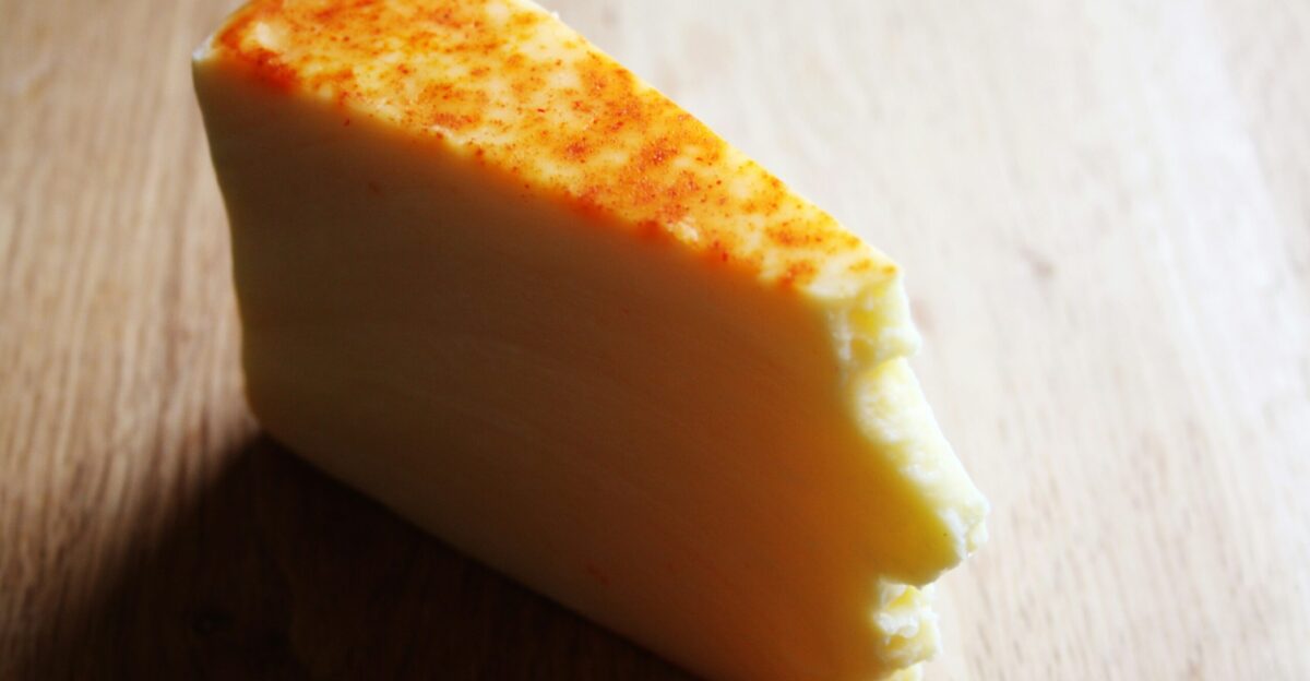 A piece of cheese sitting on top of a wooden table