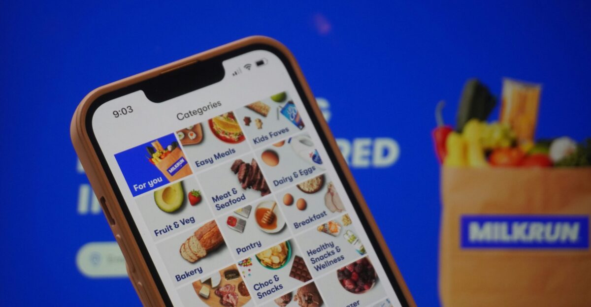 A person holding a cell phone in front of a screen