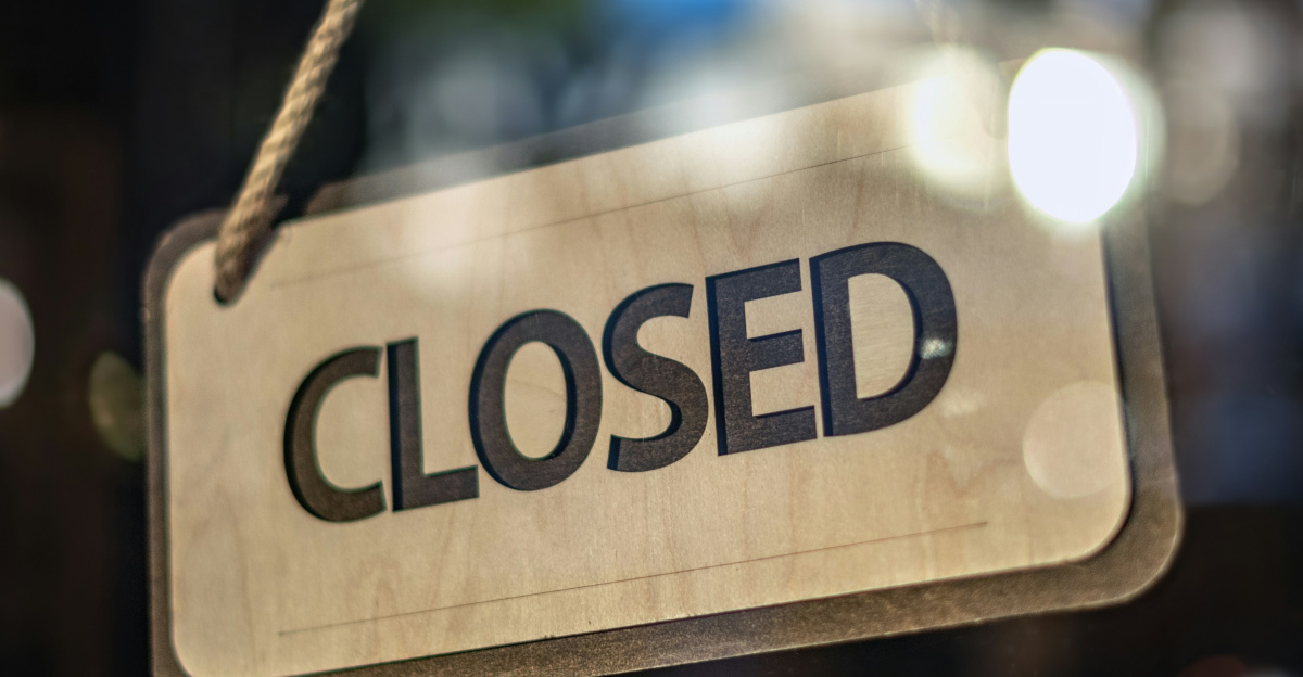 A closed sign hanging from a glass door