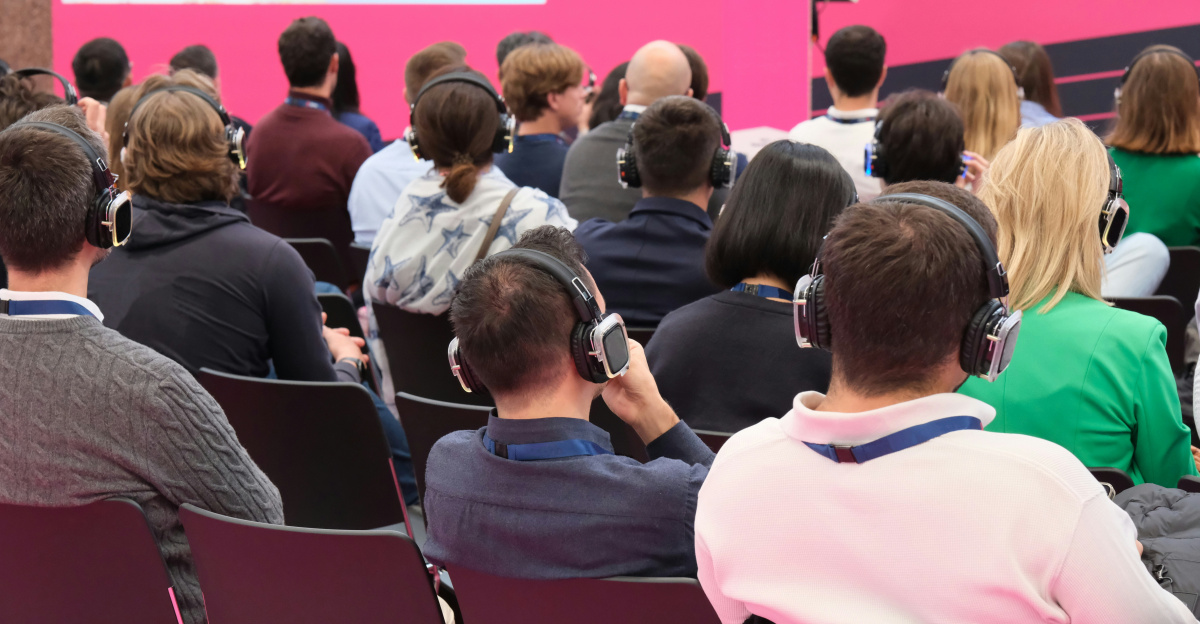 A group of people sitting in front of a pink wall