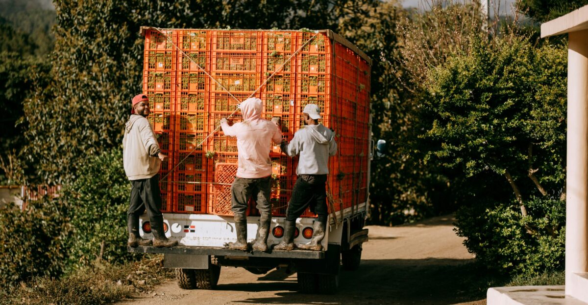 A group of people unloading a large box on the back of a truck