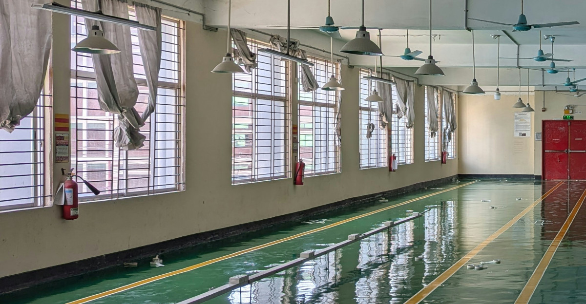 A large room with lots of windows and a ceiling fan