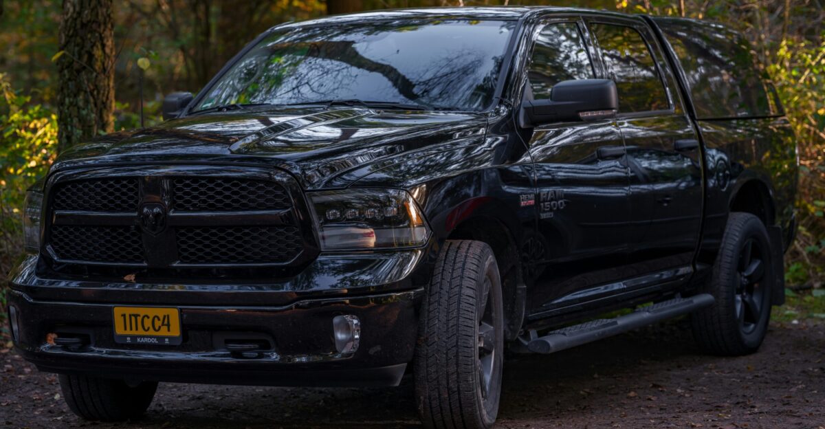 A black ram truck parked in a wooded area