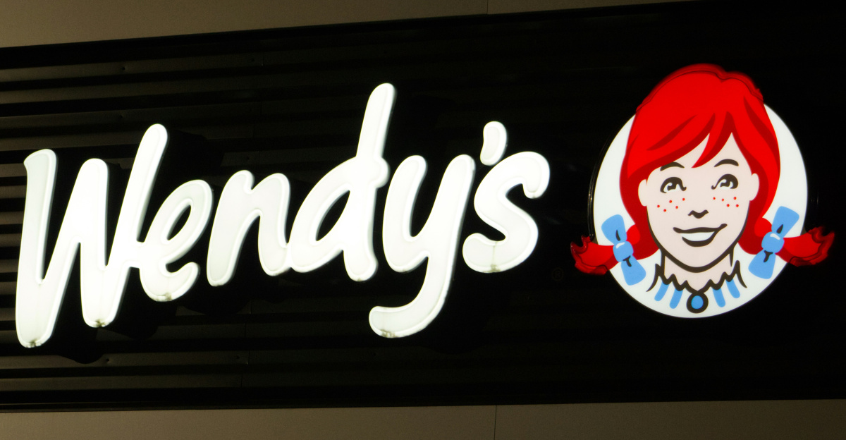A wendy's sign is lit up at night