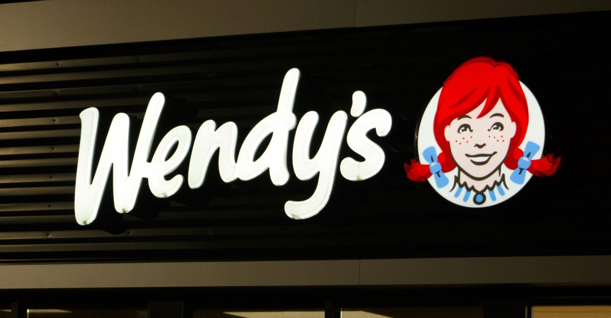 A wendy s sign is lit up at night