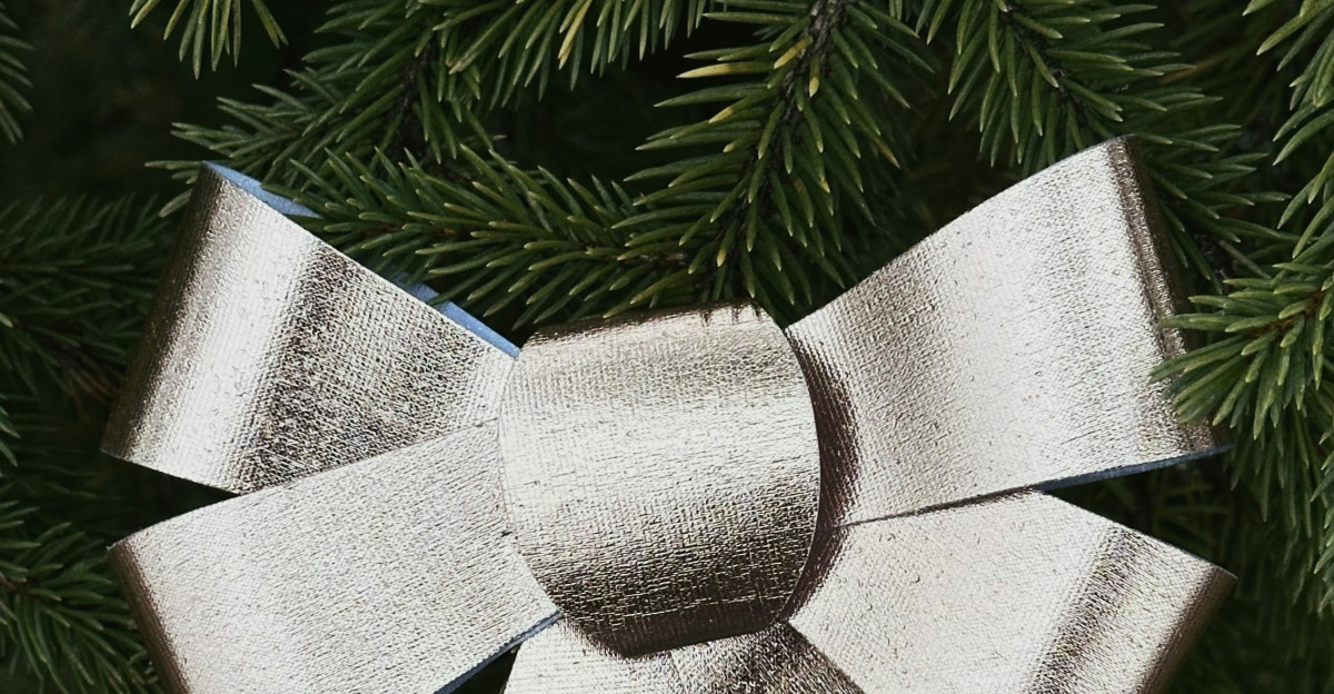 A close up of a metal bow on a christmas tree