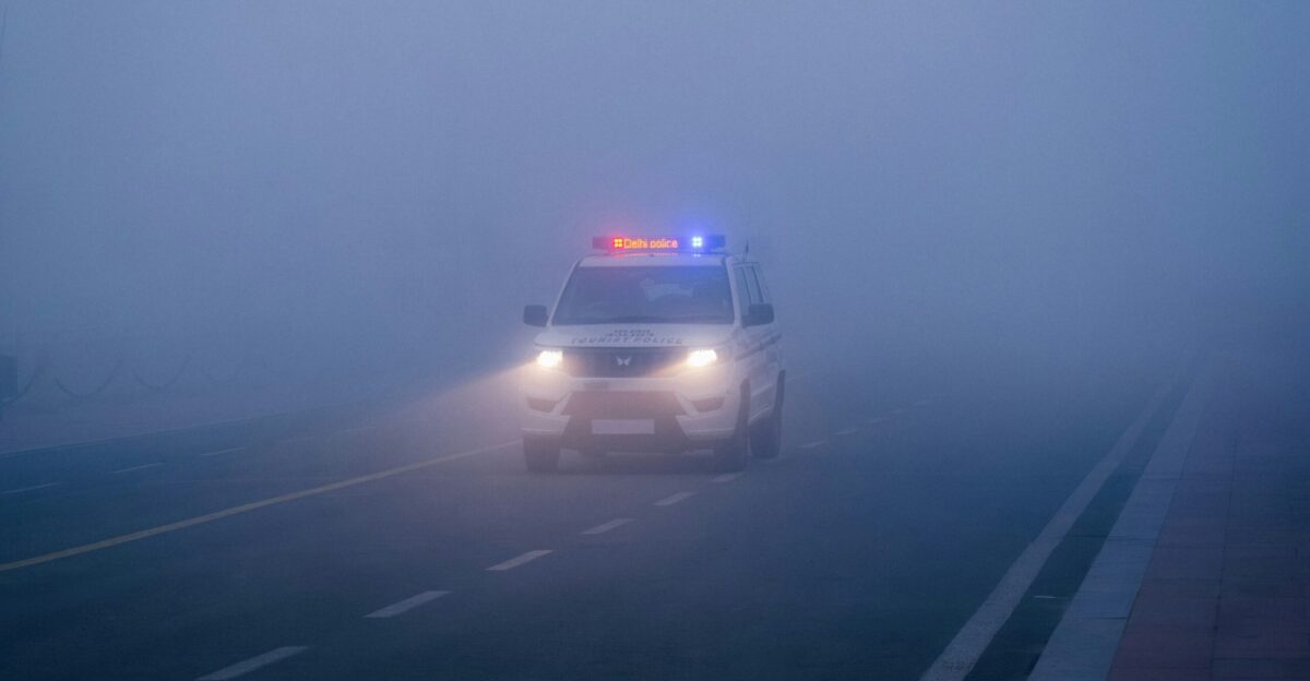A police car driving down a foggy highway