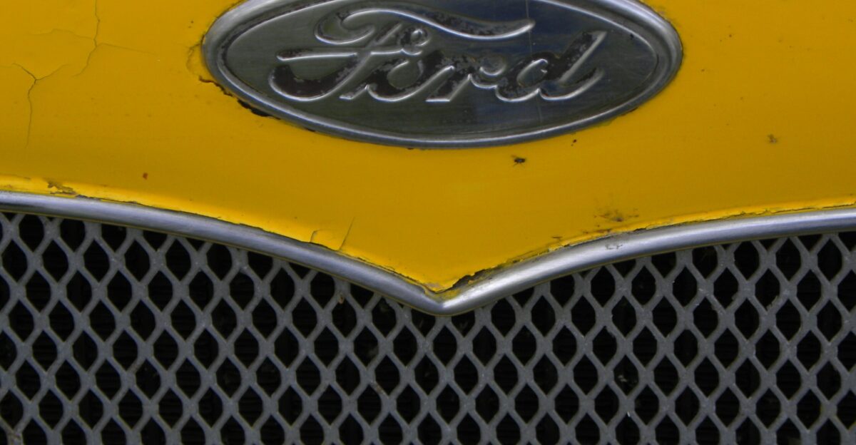 A close up of a ford emblem on a yellow car