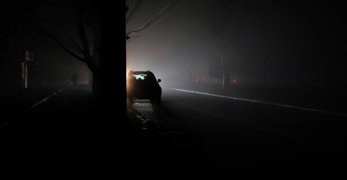 A car driving down a dark road at night