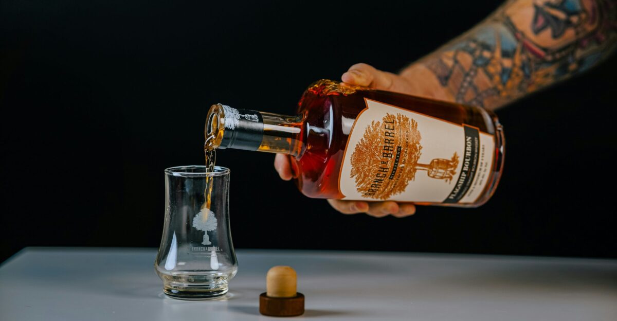A person pouring a drink into a glass