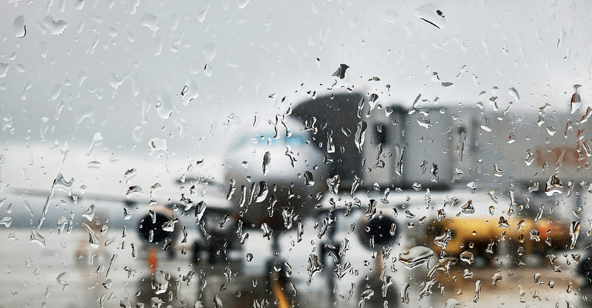 A view of an airport through a rainy window