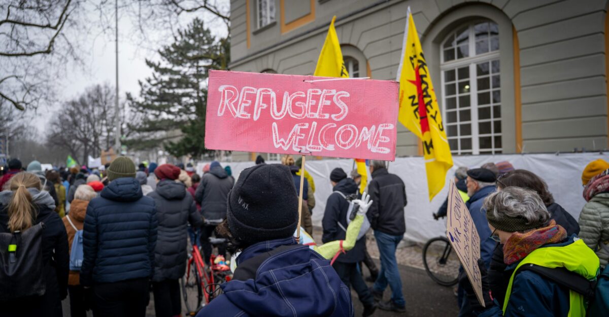 A large group of people holding signs in front of a building