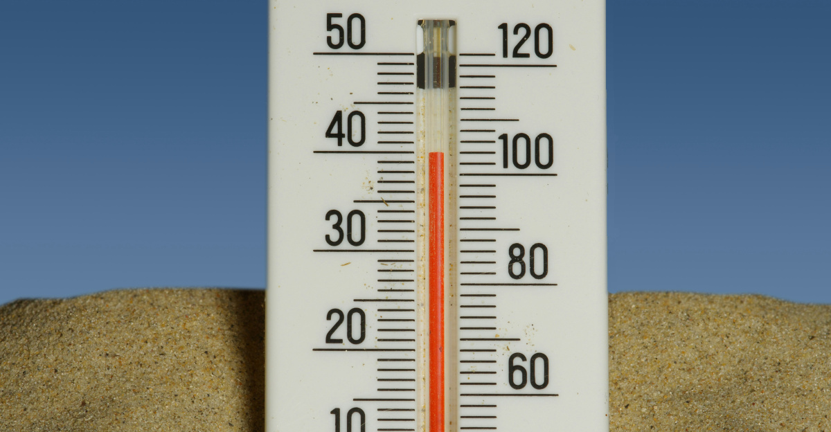 A thermometer in the sand with a blue sky in the background