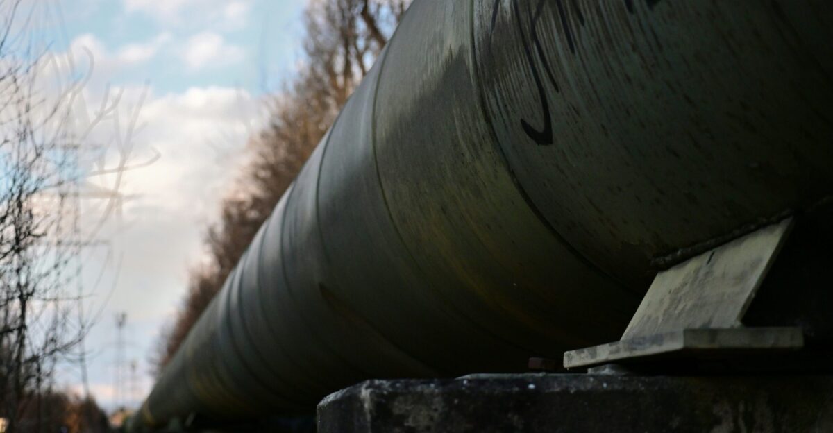 A large pipe runs alongside a road