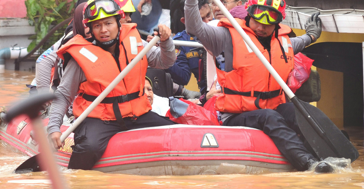 Rescue workers navigate floodwaters in a boat.
