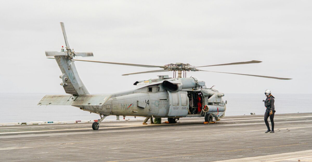 A helicopter sits on a ship deck